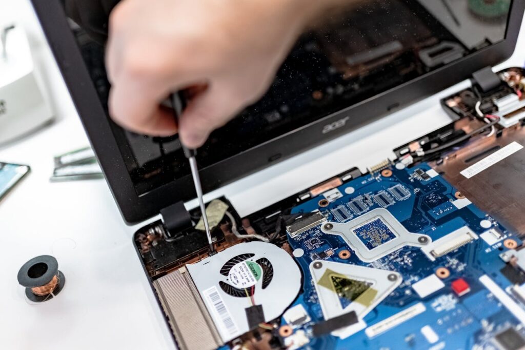 pexels photo 7639370 Technician repairing a laptop motherboard, focusing on electronic components.
